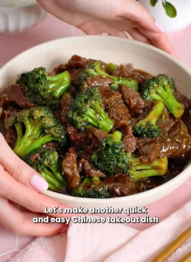 Beef and broccoli stir-fry served in a bowl with chopsticks.