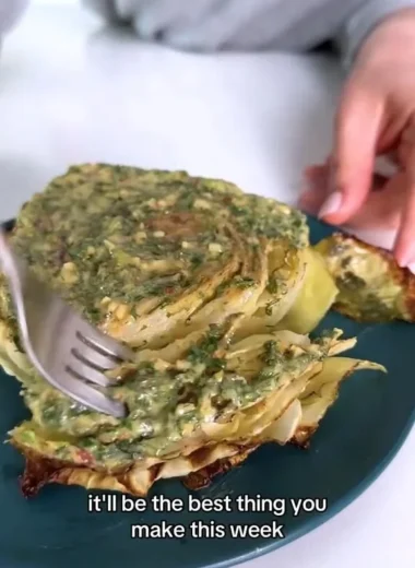 Cabbage steaks topped with herb butter served on a plate
