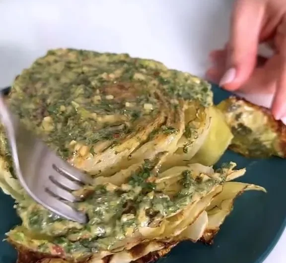 Cabbage steaks topped with herb butter served on a plate