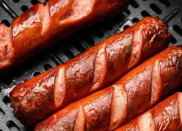 Deliciously cooked air fryer hot dogs served on a plate.