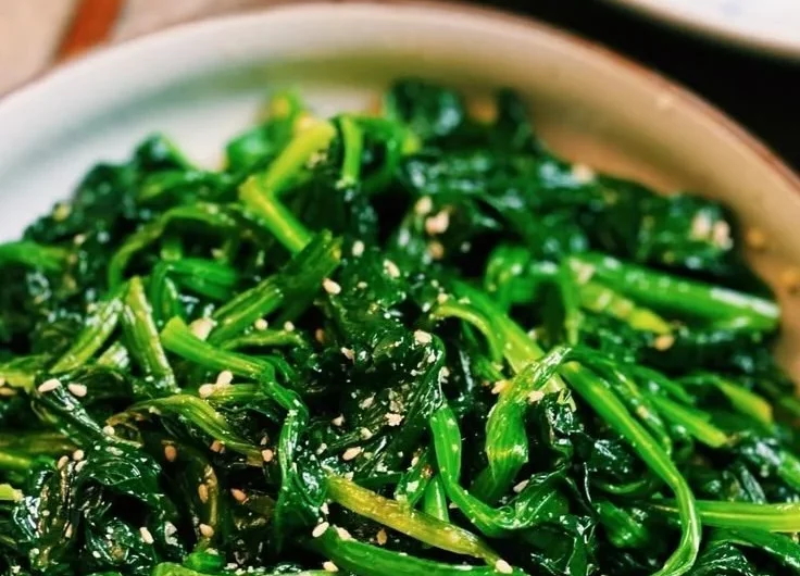 Korean Spinach Salad (Sigeumchi Namul) served in a bowl, garnished with sesame seeds.