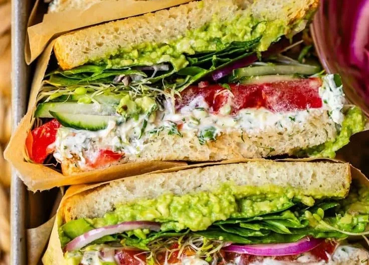 A colorful and delicious fresh veggie sandwich with assorted vegetables and bread