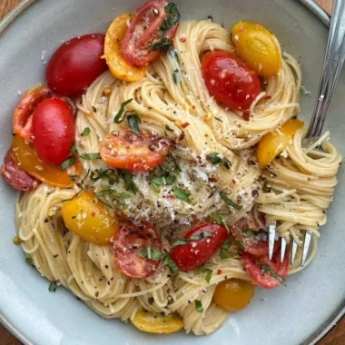 Colorful summer garden pasta topped with fresh vegetables and herbs
