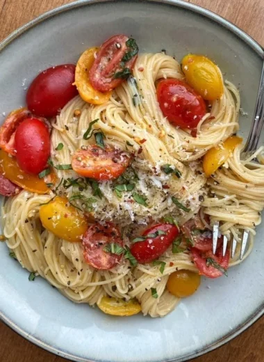 Colorful summer garden pasta topped with fresh vegetables and herbs