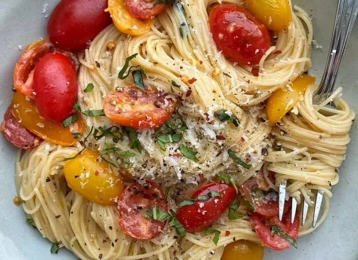 Colorful summer garden pasta topped with fresh vegetables and herbs