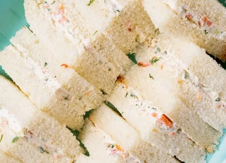 Veggie cream cheese finger sandwiches on a platter, ideal for parties