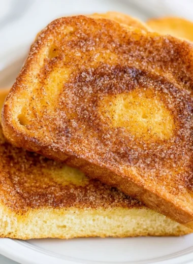 Air Fryer Cinnamon Toast served on a plate with a sprinkle of cinnamon sugar.