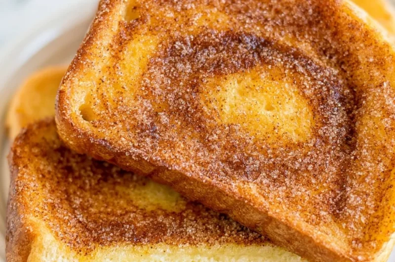 Air Fryer Cinnamon Toast served on a plate with a sprinkle of cinnamon sugar.