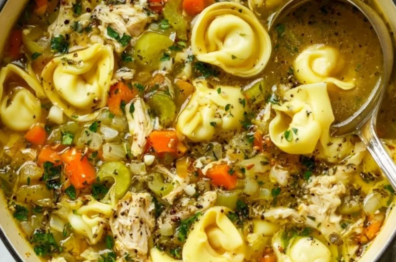 A bowl of delicious Chicken Tortellini Soup with fresh herbs and vegetables.