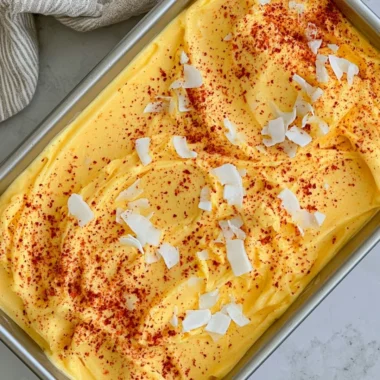 Chili Lime Mango Sorbet served in a bowl with fresh mango slices and lime wedges.