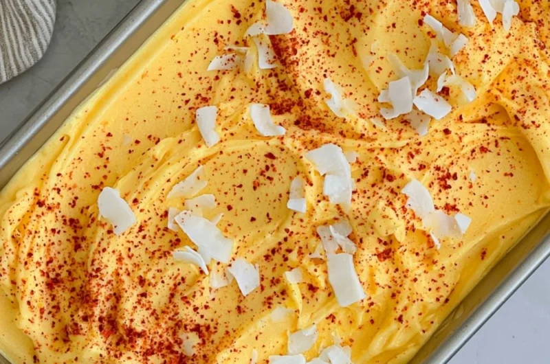 Chili Lime Mango Sorbet served in a bowl with fresh mango slices and lime wedges.
