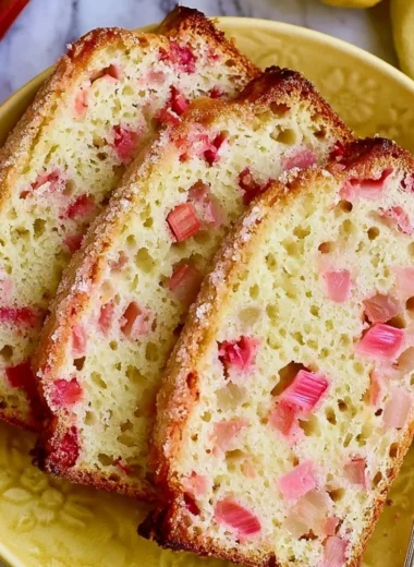 Freshly baked classic lemon rhubarb bread on a wooden cutting board