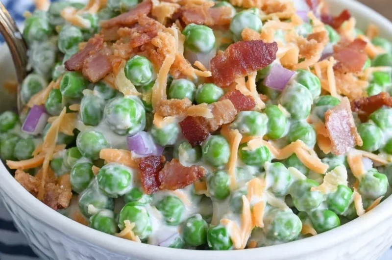 Classic pea salad with bacon served in a bowl, garnished with fresh herbs.