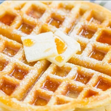 Fluffy Belgian waffles served with syrup and fresh berries