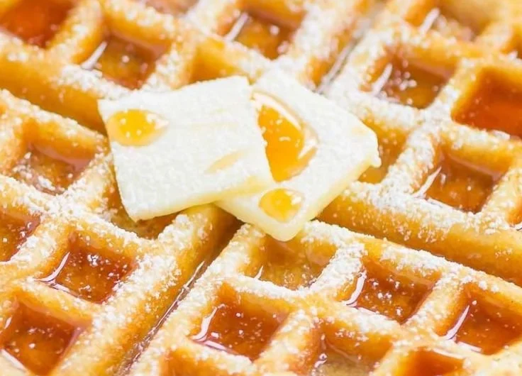 Fluffy Belgian waffles served with syrup and fresh berries