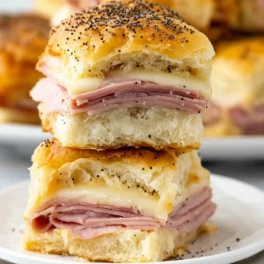 Ham and cheese sliders stacked on a serving platter, ready to be enjoyed.