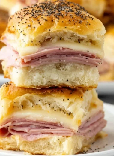 Ham and cheese sliders stacked on a serving platter, ready to be enjoyed.