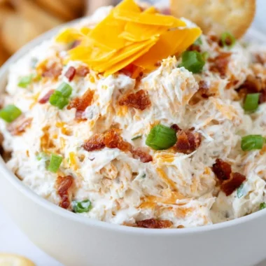Delicious Million Dollar Crack Dip served in a bowl with crackers and veggies.