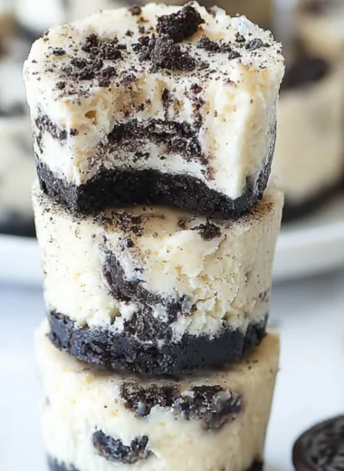 Mini Oreo cheesecakes topped with crushed Oreos on a decorative plate