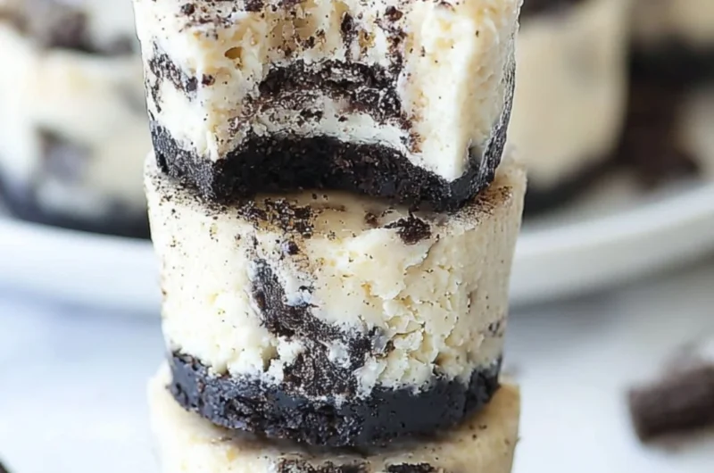 Mini Oreo cheesecakes topped with crushed Oreos on a decorative plate