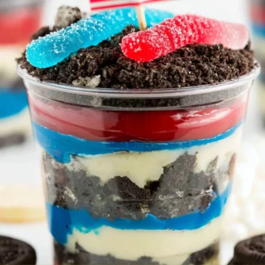 Festive Red, White and Blue Dirt Cups dessert with layers of cake and cream.