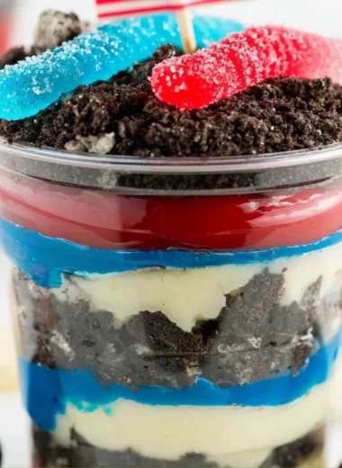 Festive Red, White and Blue Dirt Cups dessert with layers of cake and cream.