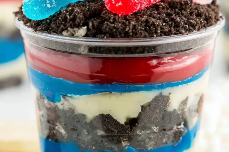 Festive Red, White and Blue Dirt Cups dessert with layers of cake and cream.
