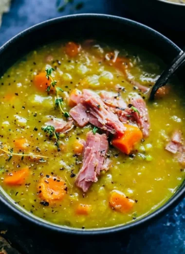 Bowl of homemade split pea soup garnished with herbs and bread