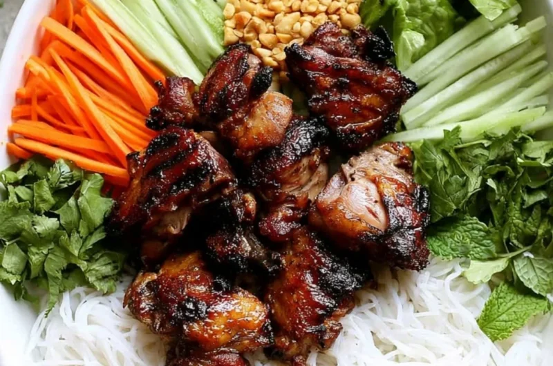 Bowl of Vietnamese grilled pork rice noodles topped with fresh herbs and vegetables