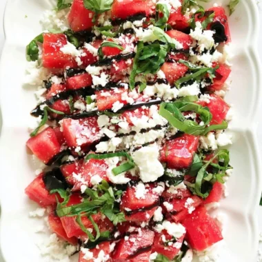 Colorful watermelon salad topped with herbs and feta cheese
