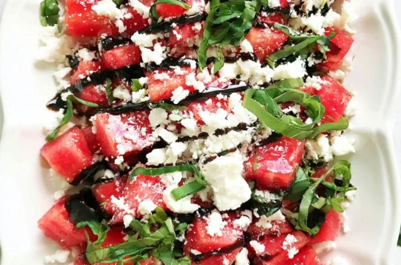 Colorful watermelon salad topped with herbs and feta cheese