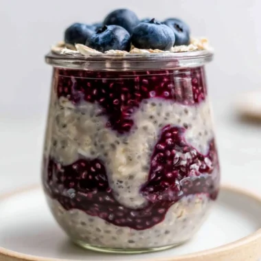 A bowl of blueberry overnight oats topped with fresh blueberries and nuts