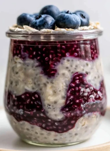 A bowl of blueberry overnight oats topped with fresh blueberries and nuts
