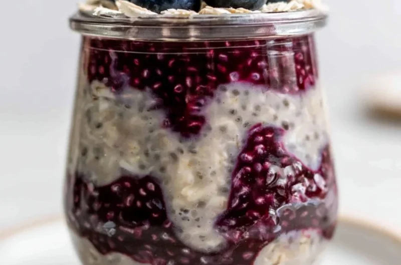 A bowl of blueberry overnight oats topped with fresh blueberries and nuts