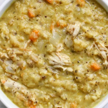 Bowl of creamy Cauliflower Chicken Soup garnished with herbs and spices.