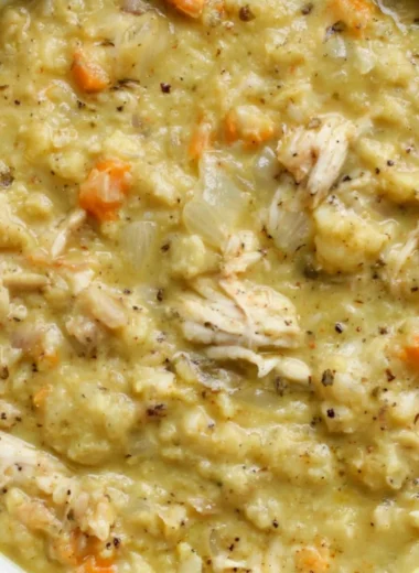 Bowl of creamy Cauliflower Chicken Soup garnished with herbs and spices.