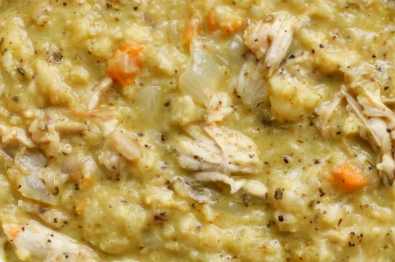 Bowl of creamy Cauliflower Chicken Soup garnished with herbs and spices.