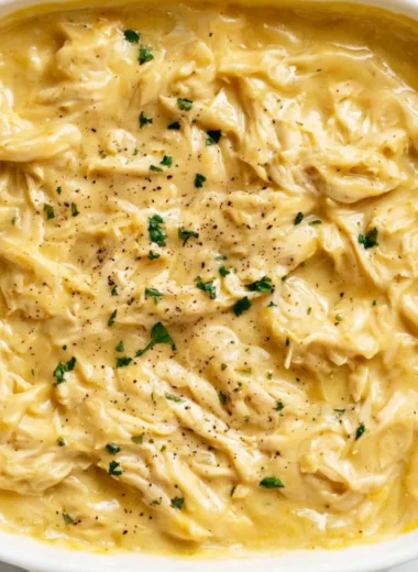 Plate of tender chicken topped with savory gravy, served with mashed potatoes.