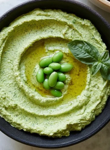 Bowl of cozy edamame hummus with fresh veggies for dipping