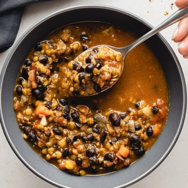 Cozy bowl of protein-packed black bean lentil soup topped with fresh herbs