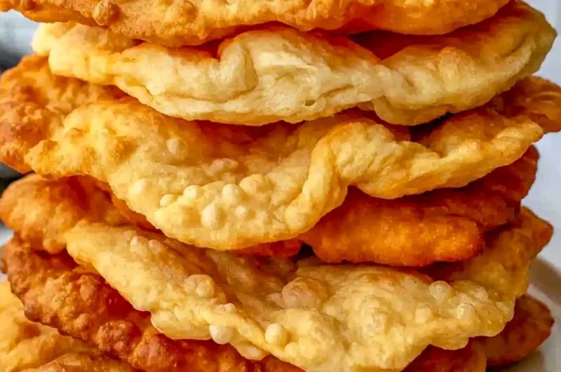 Plate of freshly made Native American Fry Bread topped with honey and powdered sugar