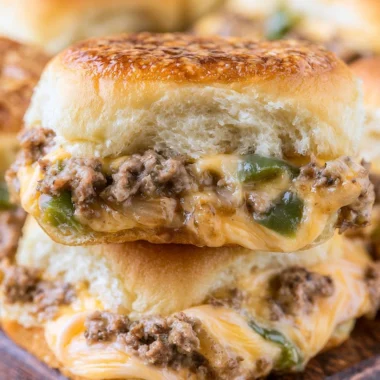 Delicious Philly cheesesteak sliders served on a platter with toppings.