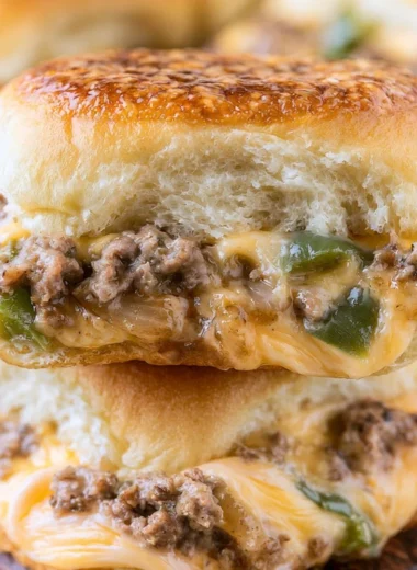 Delicious Philly cheesesteak sliders served on a platter with toppings.