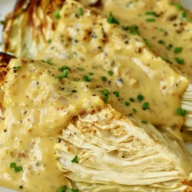 Plate of roasted cabbage wedges drizzled with onion-Dijon sauce